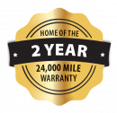 Badge-style graphic with gold and black accents displaying the text 'Home of the 2 Year 24,000 Mile Warranty' in bold white letters